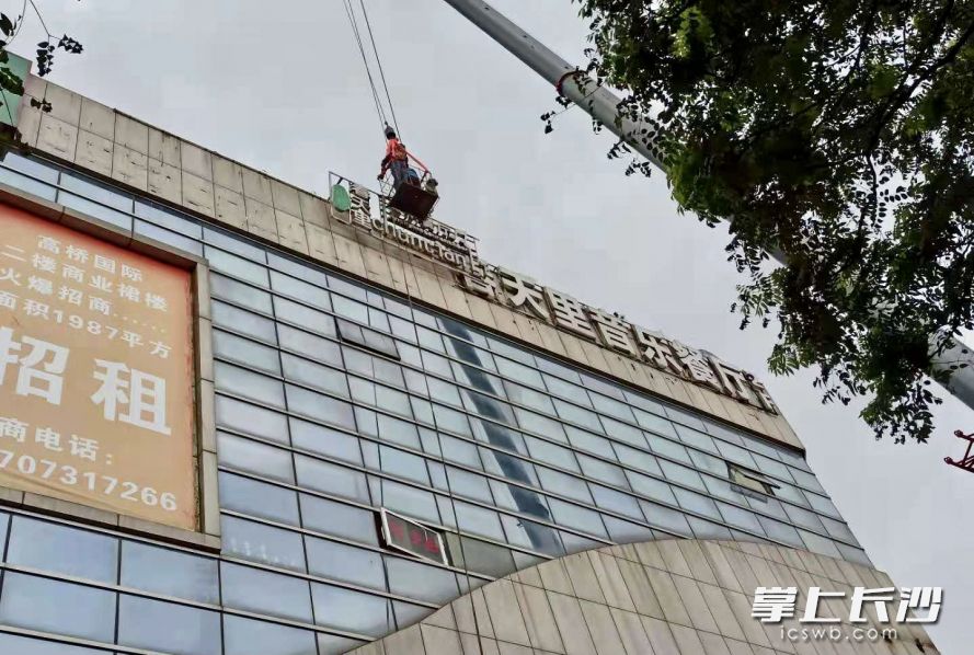 今日上午，雨花区城管执法大队高桥中队组织专业施工人员，对高桥国际楼顶一处广告进行拆除。