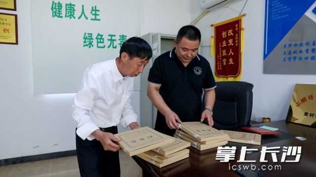 熊志钢（右）与宁乡市社会禁毒协会黄材镇分会会长沈元安（左）整理戒毒“盟约会”资料。