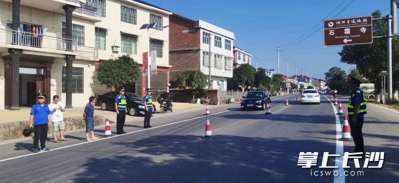 10月1日一大早，浏阳市金刚镇执法人员和志愿者便在道路上忙碌起来。