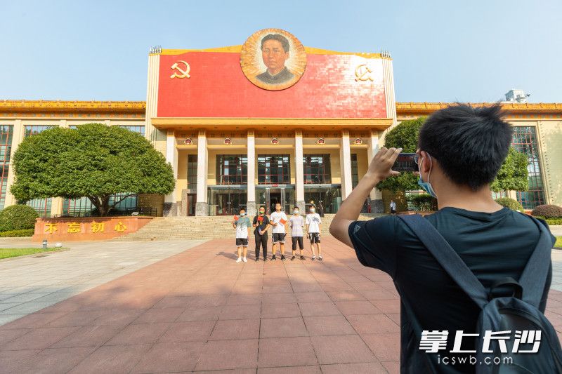 前来参观的游客在中国共产党长沙历史馆前合影。