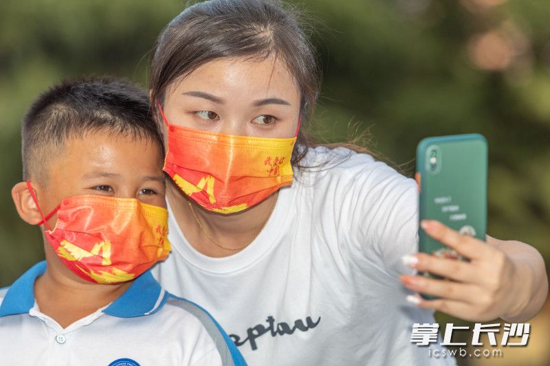 一位母子正在自拍，口罩上写着“我爱你中国”。