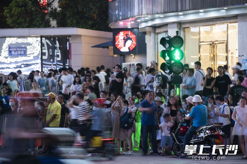 在黄兴南路，游客们在等待红绿灯通行。