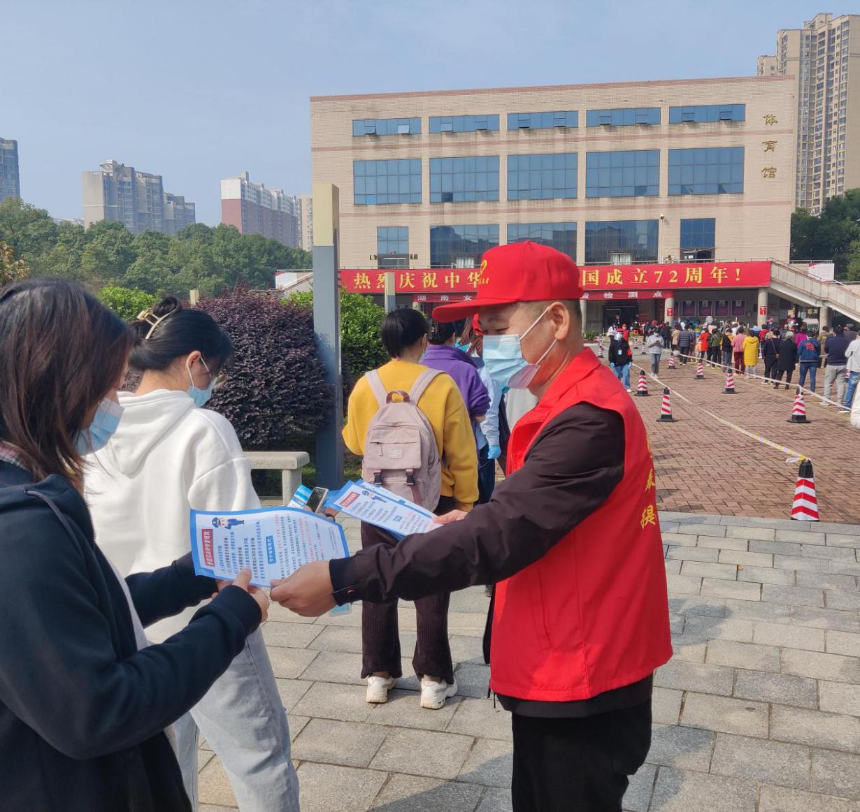 志愿者向大学生传递宣传资料。通讯员 杨广 供图