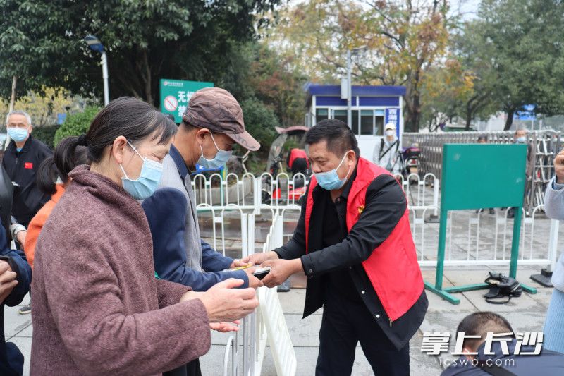 湖南省肿瘤医院门口，卢洪波（右）准时送来免费的爱心午餐。均为长沙晚报实习生 程韫玉 摄