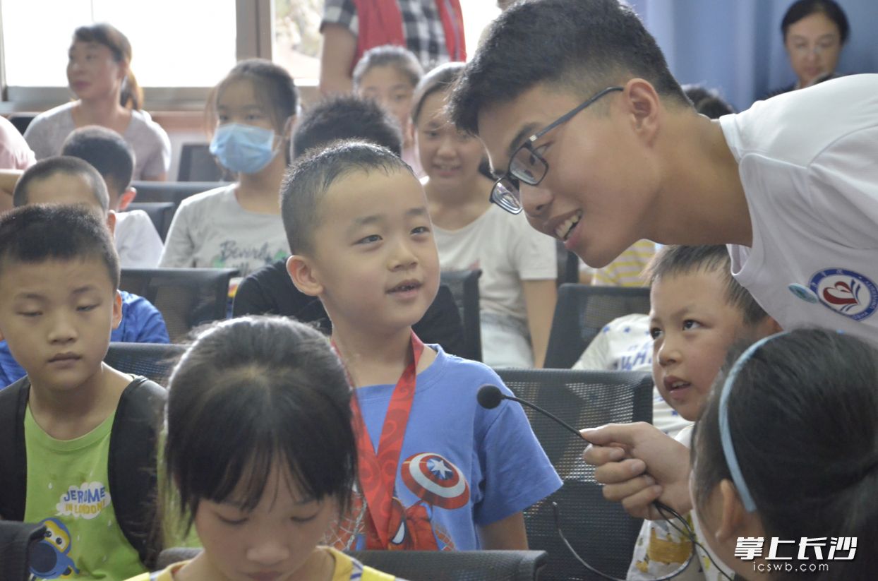 2020年7月，团队成员颜宇豪在社区就垃圾分类知识和小朋友交流互动。学校供图