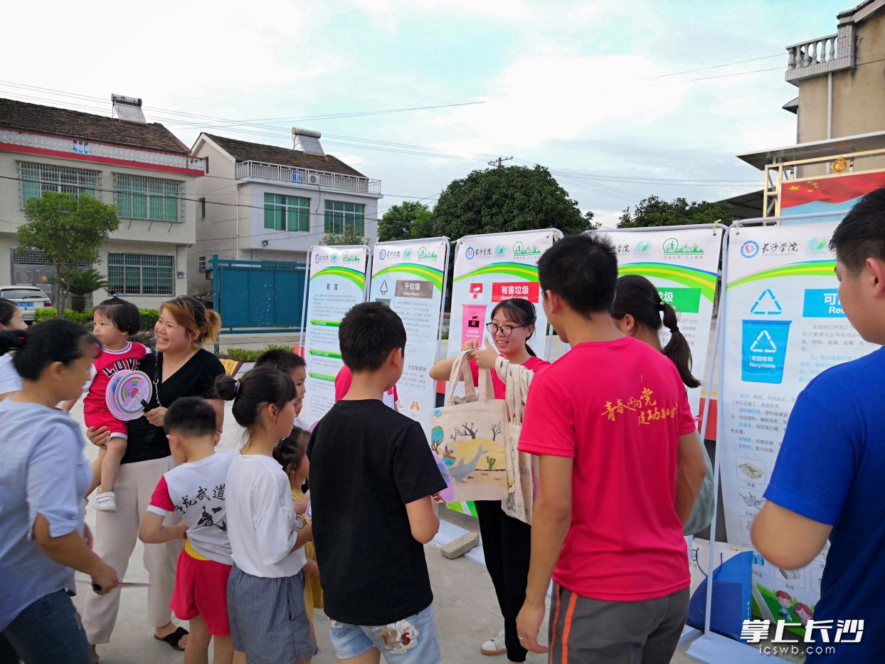 2019年7月，团队成员与下农村宣讲垃圾分类知识并发放宣传单和纪念品。学校供图