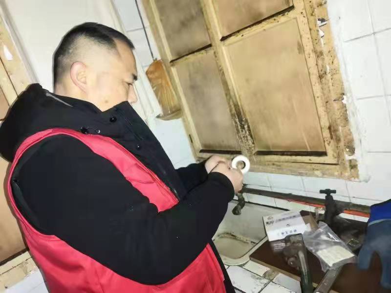杨浩正在帮老人修水管。
