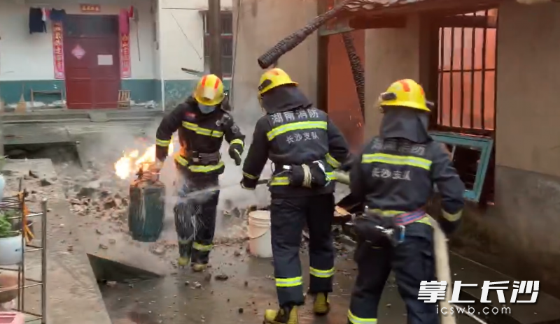 消防员从火场将燃烧的煤气罐拎出。均为长沙晚报通讯员 冯运文 供图