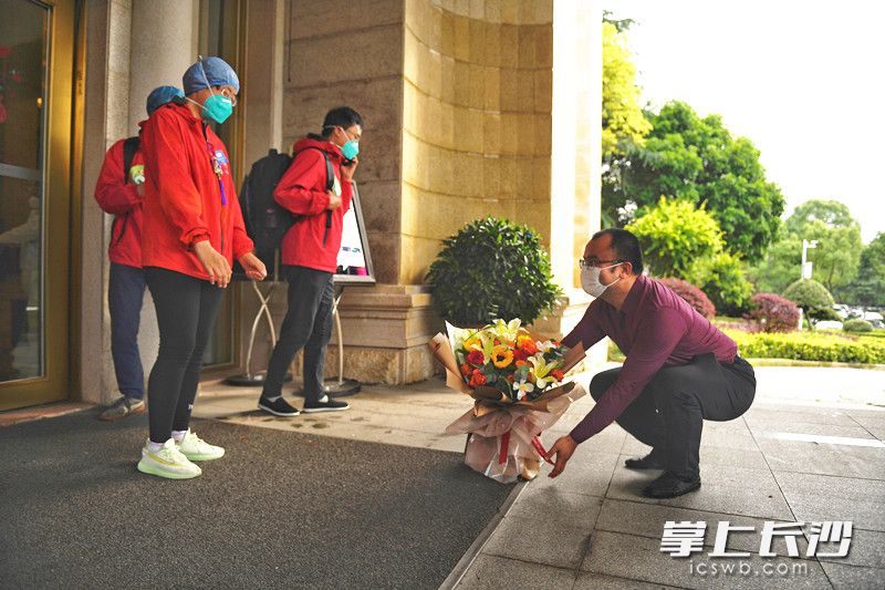 湖南中医药大学第一附属医院医疗队员张建影的爱人杨先生，手捧一束鲜花送给抗疫出征回来的妻子。