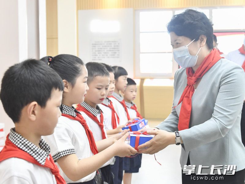 在开福区清水塘小学，吴桂英向城市新居民子弟代表赠送儿童节礼物。长沙晚报全媒体记者 余劭劼 摄