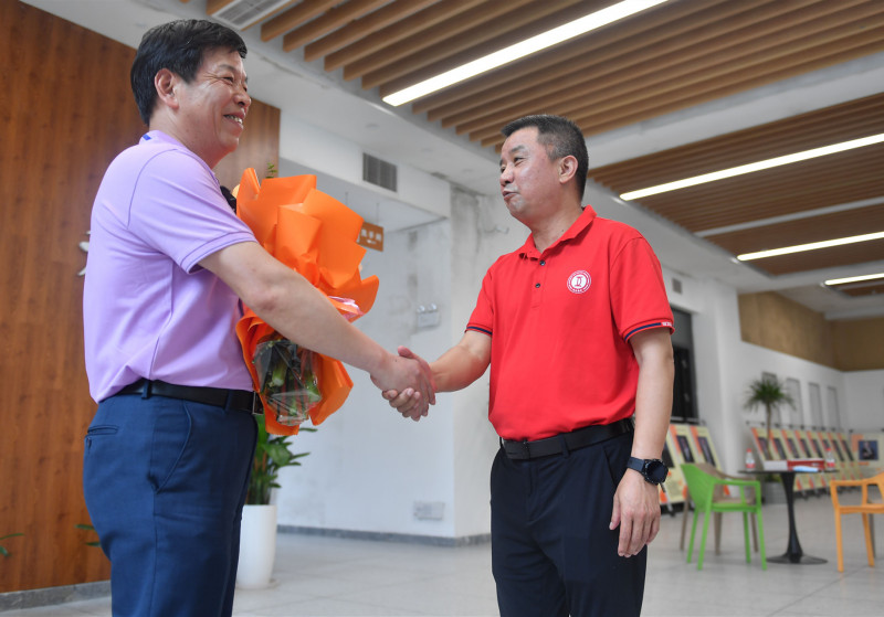 恒定中学校长蒋明权（右）给付碧才老师送上鲜花表示慰问。