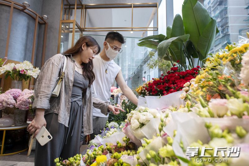 七夕来临，市民在花店选购鲜花。