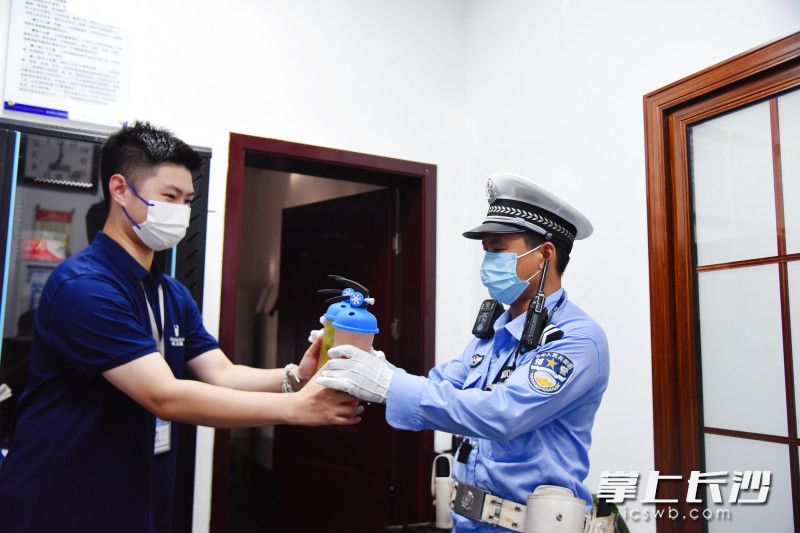 在交警岗亭，茶百道工作人员为执勤交警送茶饮品。