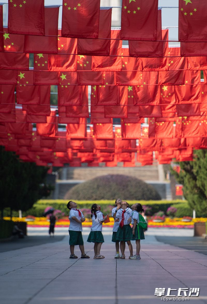 烈士公园南门广场，来自劳动东路小学的学生们在国旗下自由的奔跑，脸上露出了幸福的笑容。长沙晚报全媒体记者 黄启晴 邹麟 摄