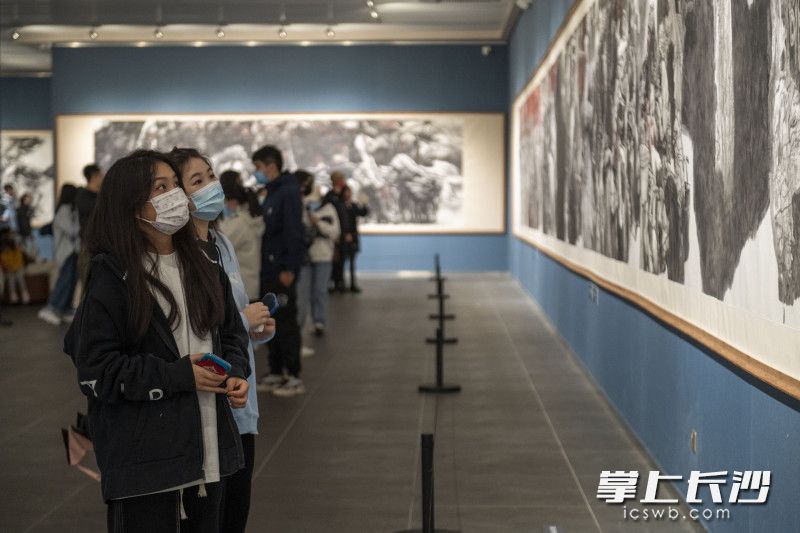 在李自健美术馆内，游客们佩戴好口罩观看美术作品。