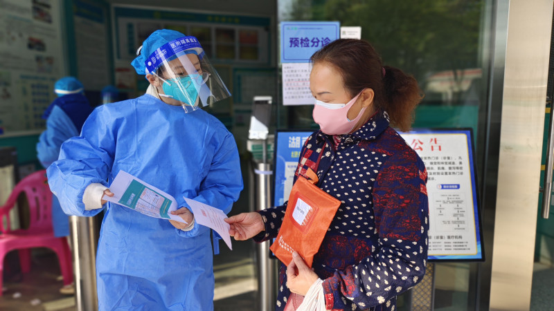 在开福区芙蓉北路街道社区卫生服务中心，医护人员向领取防疫健康包的群众告知居家治疗的知识。  长沙晚报全媒体记者 彭放 摄
