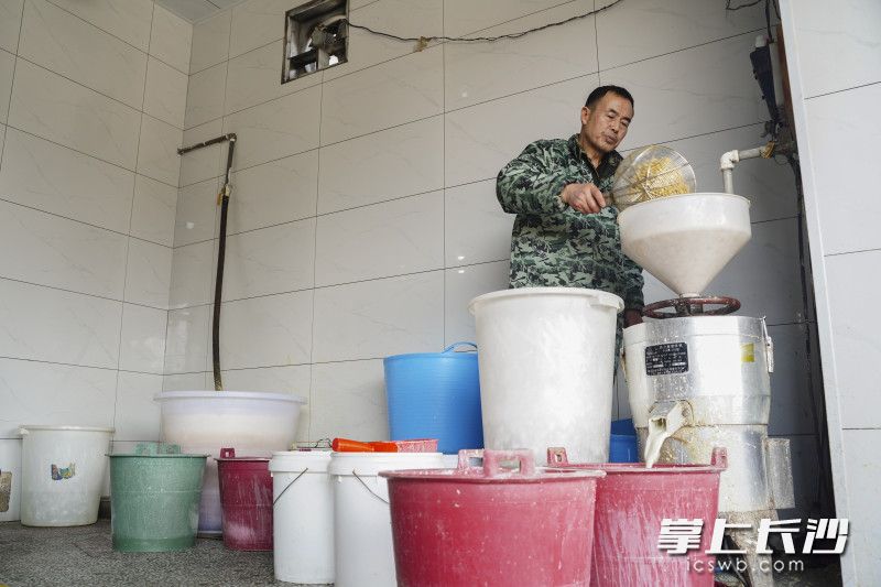 周林军正在用机械将泡好的黄豆磨浆。长沙晚报全媒体记者 刘晓敏 摄