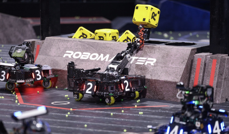 比赛中，工程机器人正用机械臂获取“金矿石”。