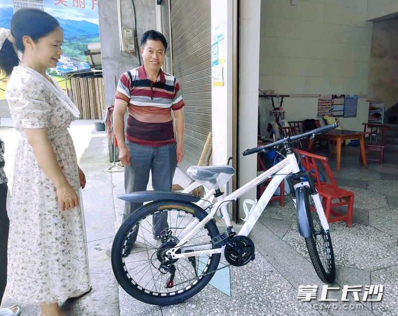 镇村干部把自行车送上户。