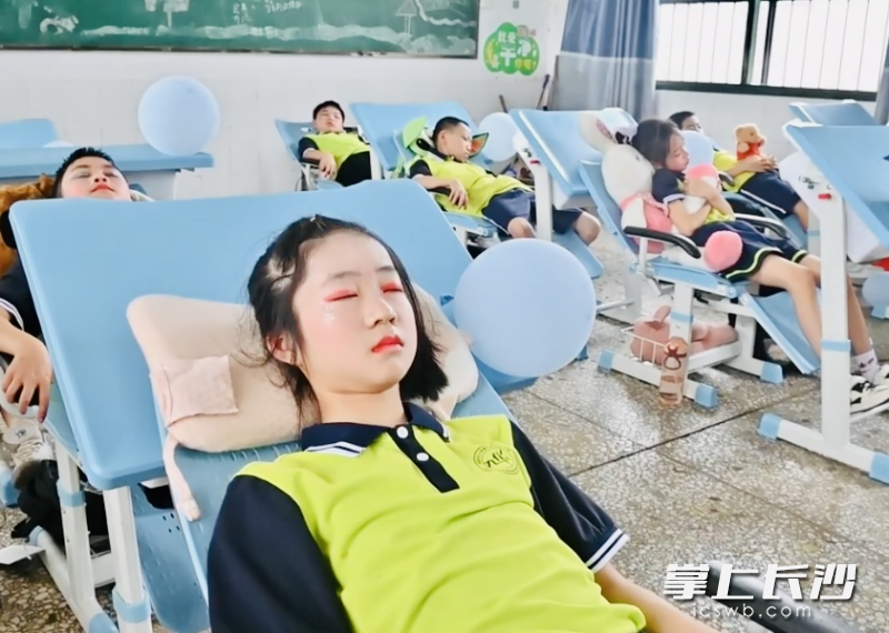 5月31日，参加完“六一”文艺汇演的孩子们正躺在新式课桌椅上午休。受访者供图