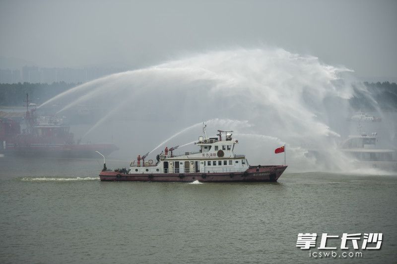 “长沙消防救援01号”消防艇与老消防艇共同对“起火船只”进行“灭火”。