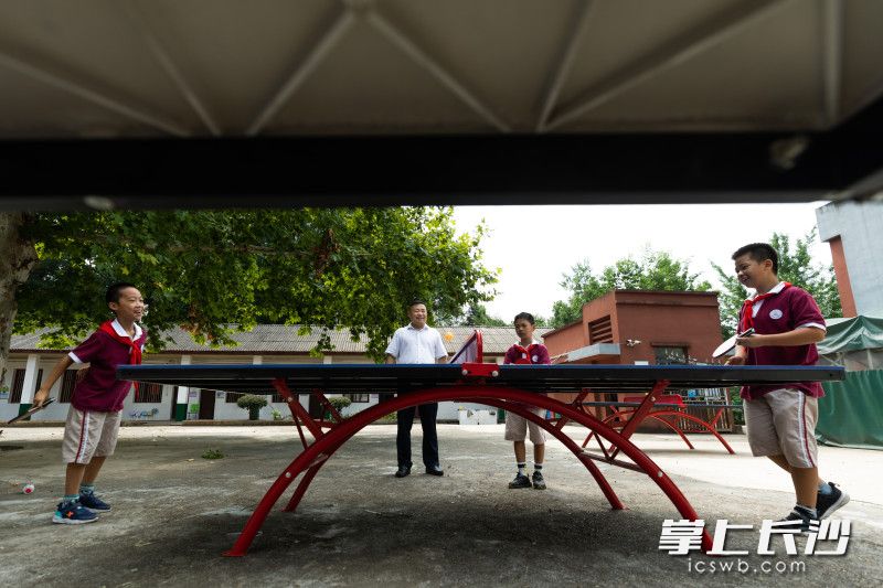 8月31日，在新装好的两张乒乓球桌前，孙家闯看着孩子们打乒乓球。  均为长沙晚报全媒体记者董阳摄