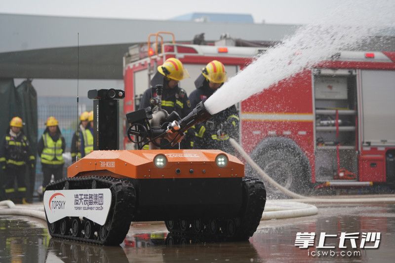 演练中，“火焰蓝”和消防机器人并肩作战。长沙晚报通讯员 张佳欣 供图