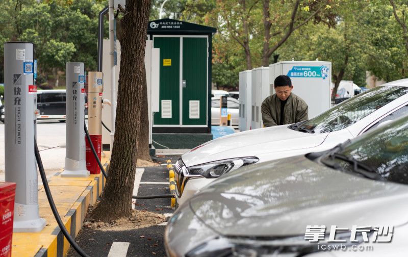 在芙蓉区的一个公共充电站，车主准备给新能源汽车充电。