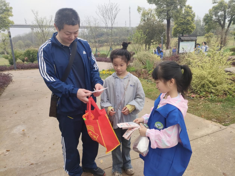 宁乡市林小青实践中心的小小志愿者向群众宣传清明节文明祭祀。