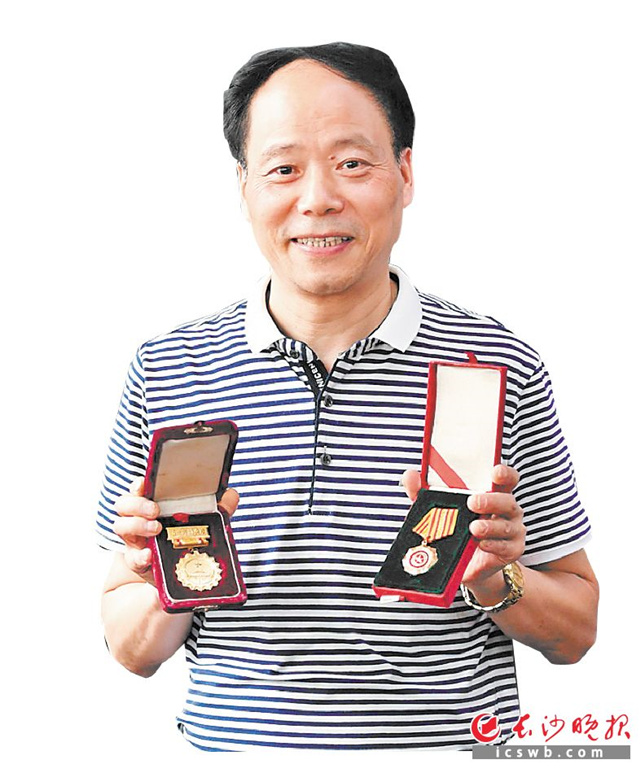 吴冬林展示自己的全国五一劳动奖章和“全国新长征突击手”奖章。长沙晚报全媒体记者 王志伟 摄