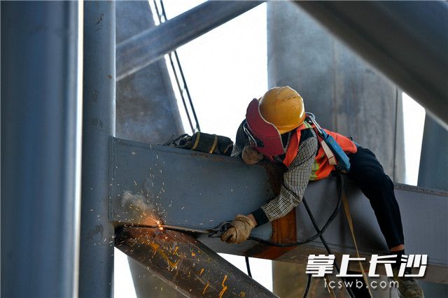 长衣长裤、面罩手套，“铁裁缝”们全副武装，爬在钢结构上进行焊接。