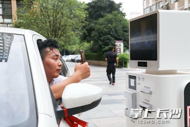 车主可自主扫描停车机器人上显示的二维码进行缴费。柯鸣 摄