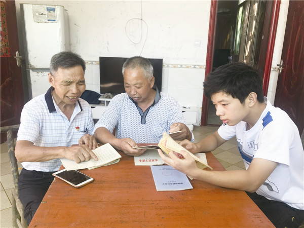 朱明超（左一）正和江志平一家人重温夜校课本。