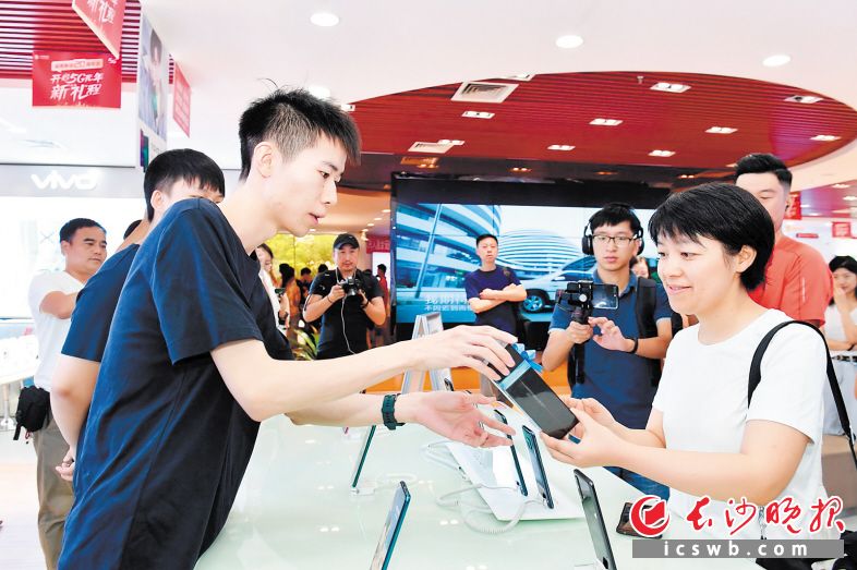 16日上午，长沙市民熊女士（右一）购得一台华为Mate 20 X（5G），成为湖南首名5G体验客户。 长沙晚报全媒体记者 王志伟 摄