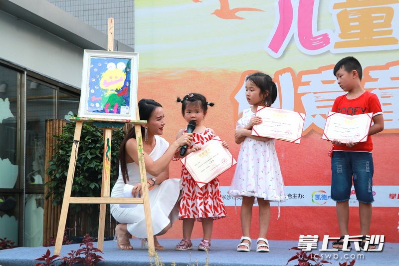 年仅三岁的获奖选手朱子妍（左二）分享她的作品。