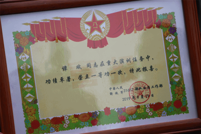 ▲为荣立一等功的现役军人谭斌家庭送立功牌匾和喜报。