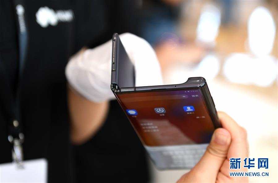 10月23日，工作人员在发布会上展示华为可折叠全面屏5G手机Mate X。新华社记者 毛思倩 摄