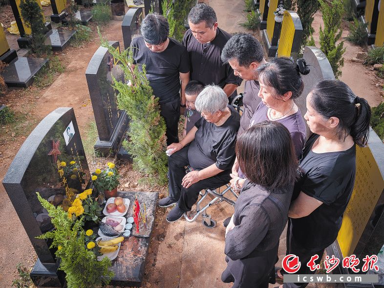 图为王志华带着亲人们在粟绍其墓前祭奠。