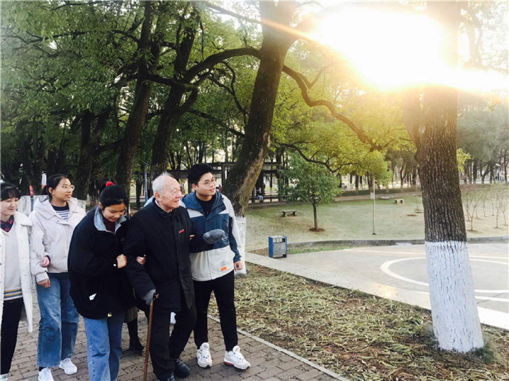 12月10日，沧南（右二）和湘潭大学本科生们在校园里散步。新华社记者 袁汝婷 摄