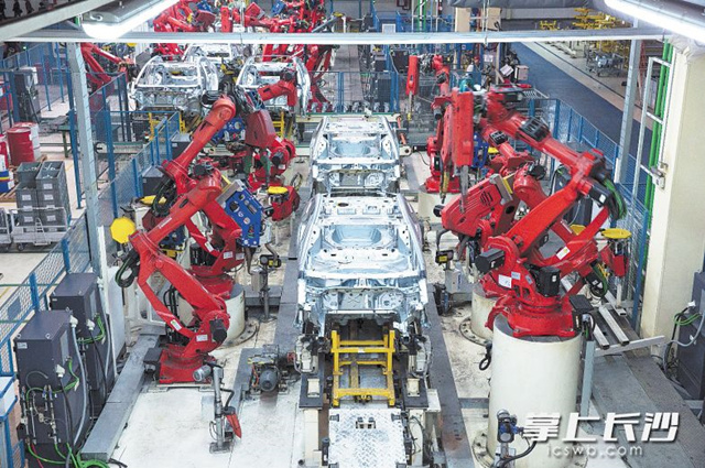 广汽菲克焊接车间内，机器人手臂在进行车体焊接。长沙晚报全媒体记者 王志伟 摄