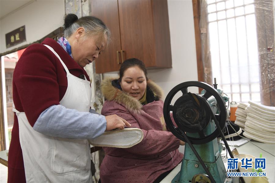 1月10日，在四川成都，唐昌布鞋传承人赖淑芳（左）在指导工人制作布鞋。新华社记者刘坤摄