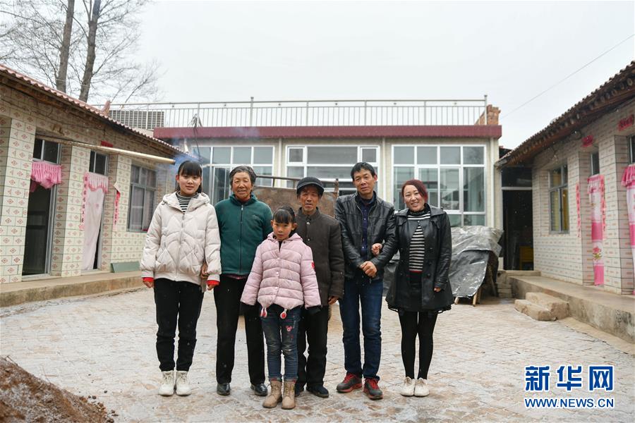 1月9日，在甘肃省定西市渭源县元古堆村，韩丽军（左一）一家在新房前拍摄全家福。新华社发（马希平 摄）