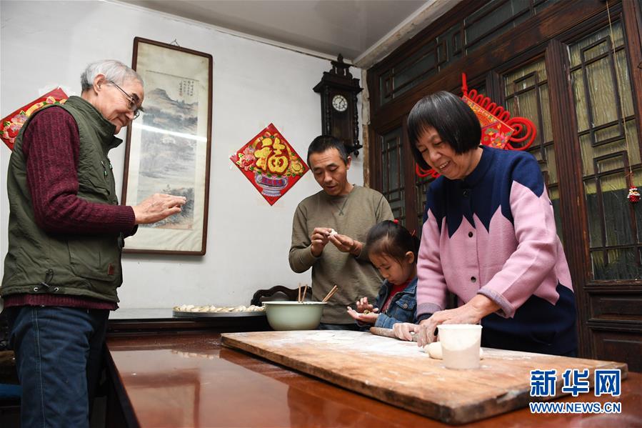 1月14日，在北京前门东区草厂四条胡同，朱茂锦老人（左一）和家人一起包饺子。新华社记者鞠焕宗摄