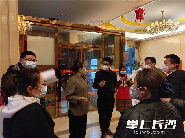 姚晶（左四）现场调度对疫源地人员开放定点服务酒店防疫工作。