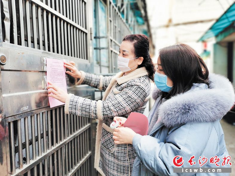 　　退休党员熊天英和女儿刘璇在芙蓉区汤家岭社区张贴防疫告示。长沙晚报全媒体记者 周游 通讯员 张斯雅 摄影报道
