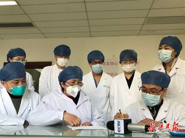李兰娟院士（第一排中间）与武汉大学人民医院医生交流新的治疗方案。记者 黄琪 摄