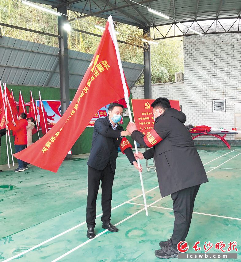 2月3日，坪塘街道工委书记陈海军（左一）向成立的12支战“疫”党员先锋队队长授予“战旗”。均为 房华建 供图