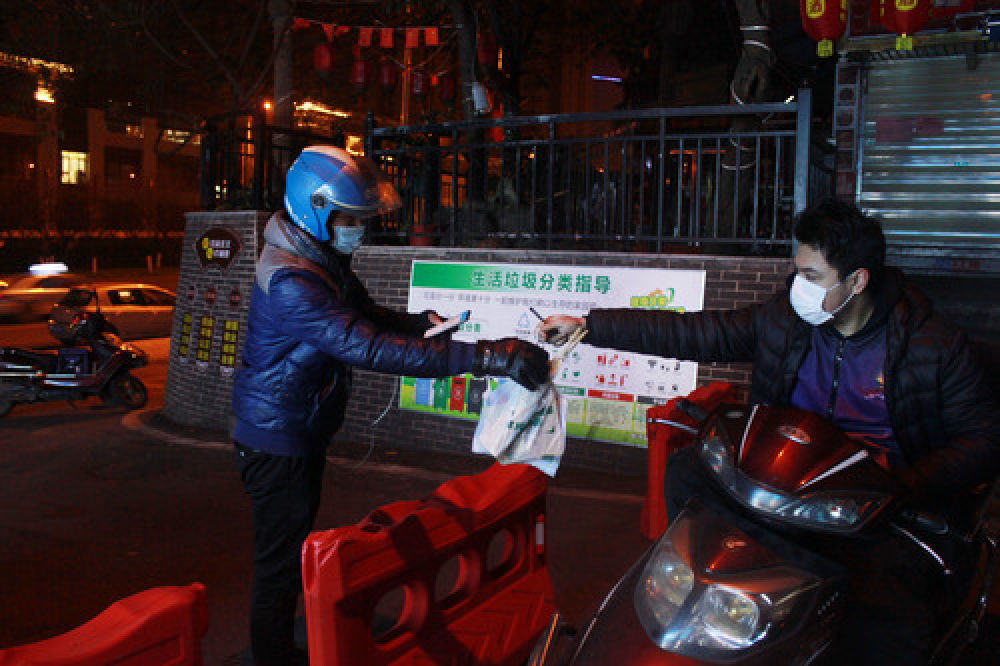 2月20日晚，在长沙市雨花区砂子塘“夜宵一条街”，外卖小哥正在取顾客从网上订购的夜宵。 新华社发（熊其雨摄）