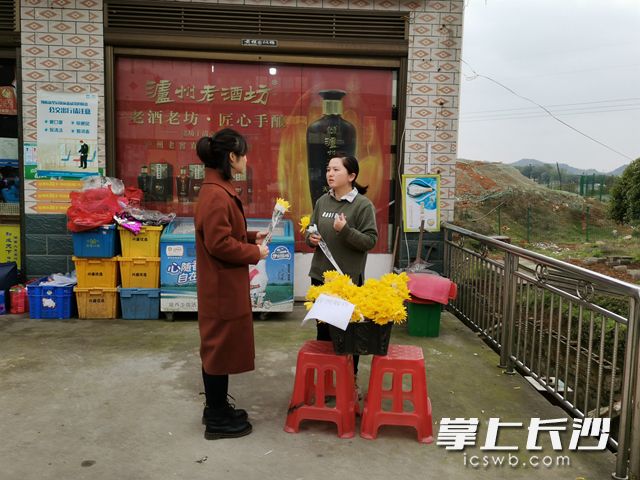 白马街道志愿者向上山祭扫的居民免费发放鲜花。 通讯员供图