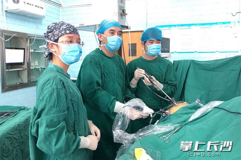 长沙市第一医院普外科副主任、主任医师杨运泉（中）手术团队在为陈女士实施腹腔镜袖状胃切除手术。